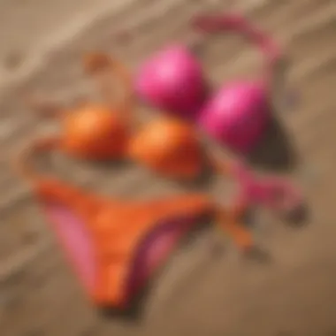 An array of colorful bikinis arranged aesthetically on a sandy surface