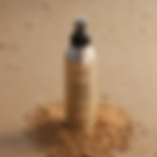 A bottle of beach club hair spray nestled in coastal sand